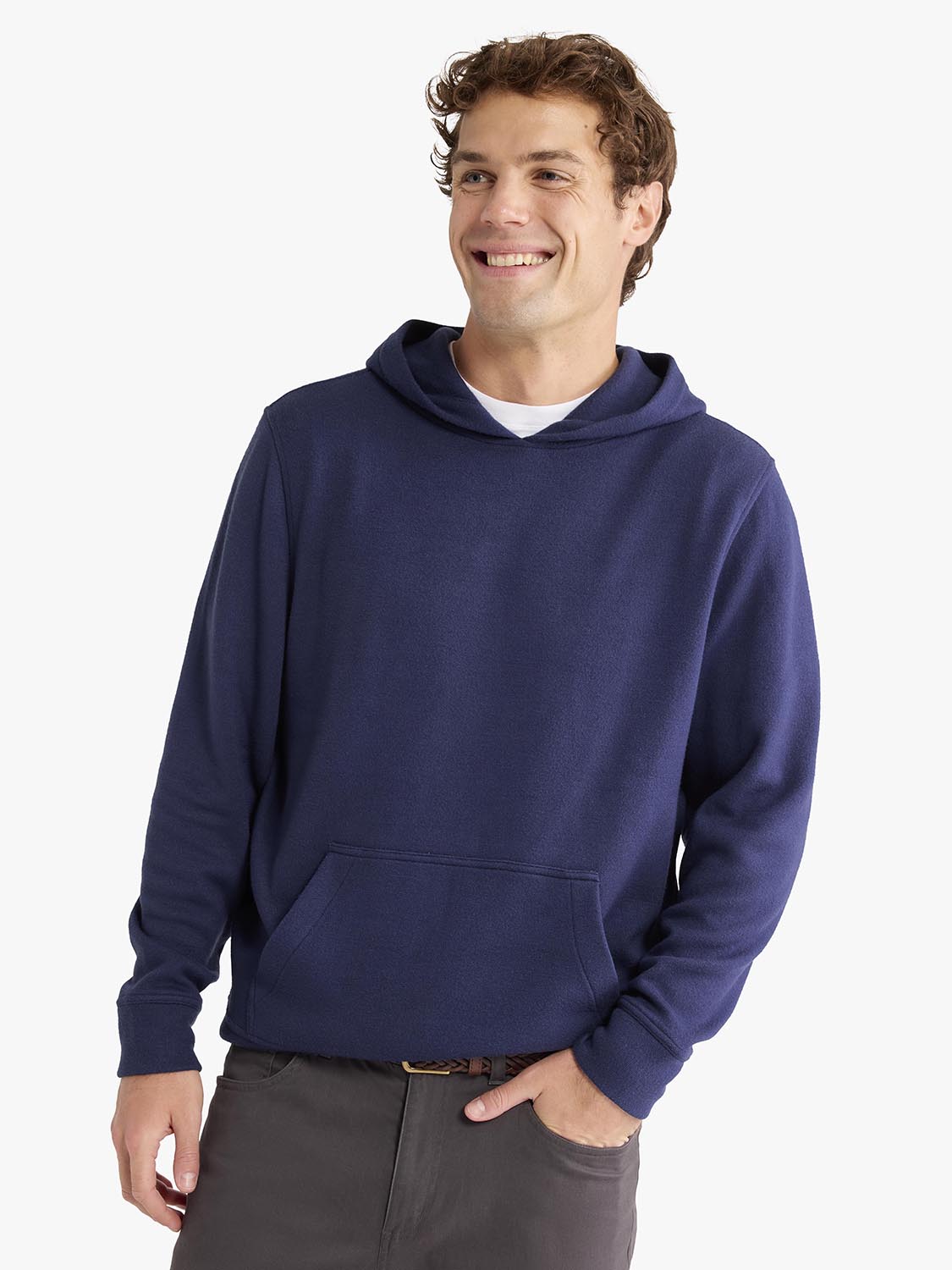 Man wearing a navy hoodie with kangaroo pocket over a white t-shirt and gray pants.
