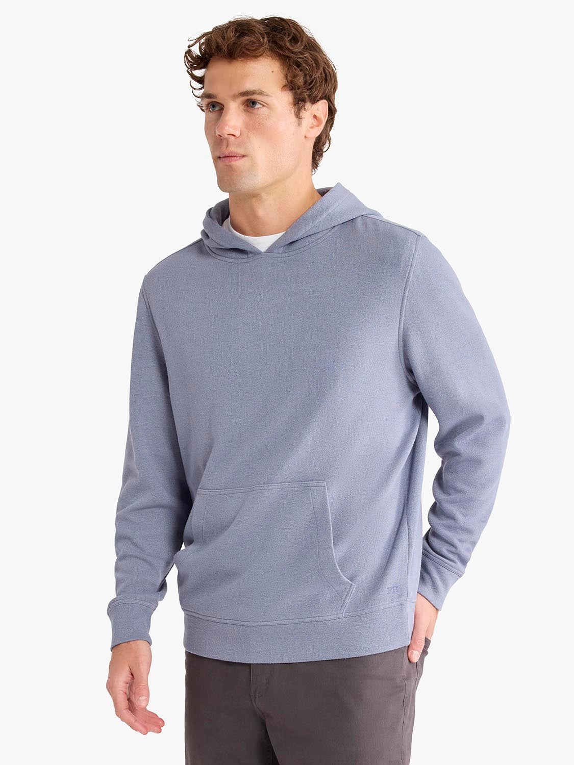 Man wearing a blue-gray blanket hoodie with a front pocket and drawstring hood.