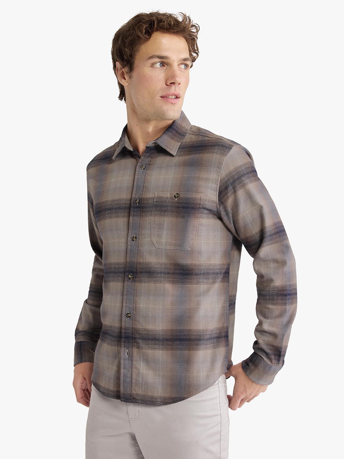 Man wearing sand ombre plaid flannel shirt with button front and chest pocket.