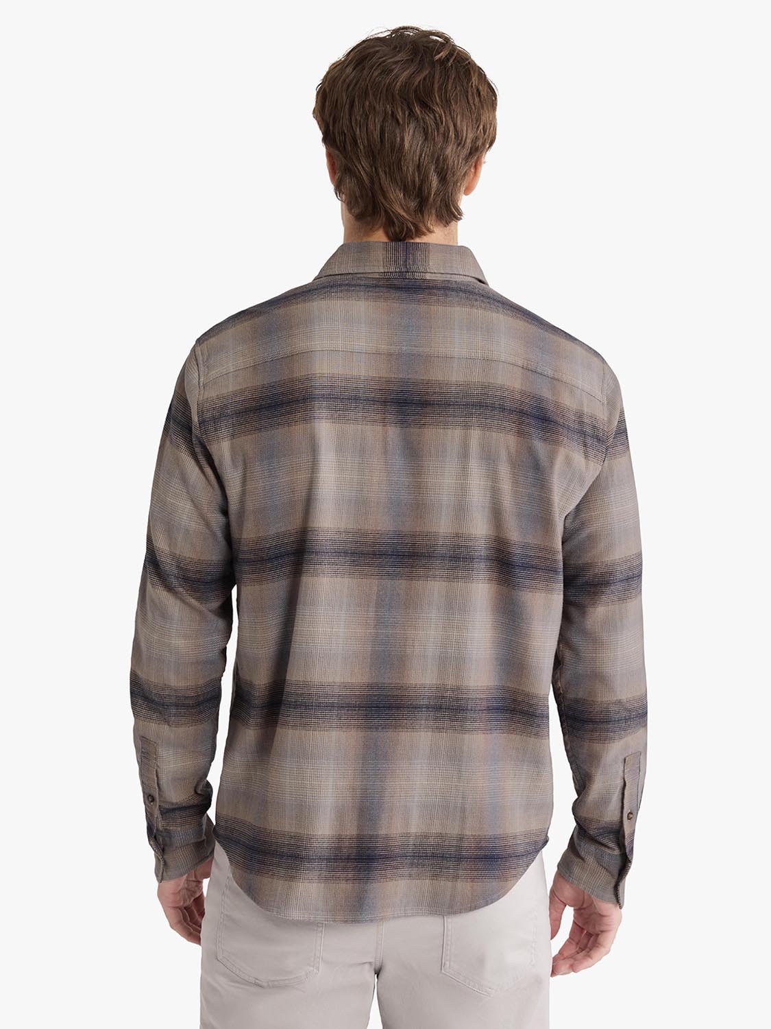 Man wearing a sand ombre flannel shirt with horizontal stripes, shown from the back.