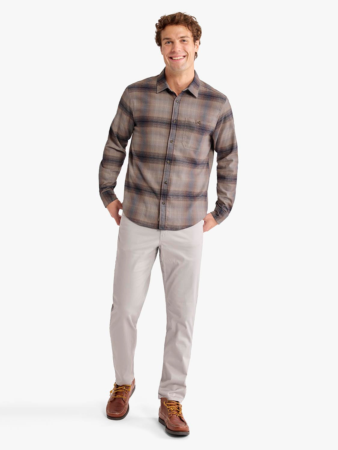 Man wearing sand ombre plaid flannel shirt with beige pants and brown boots.
