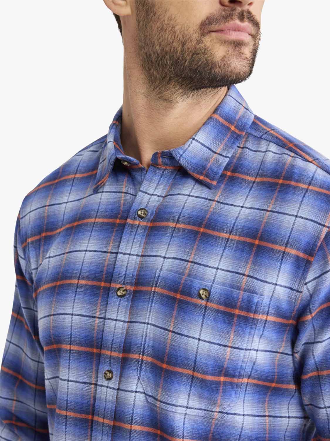 Man wearing a blue plaid flannel shirt with orange and white grid pattern and button front.
