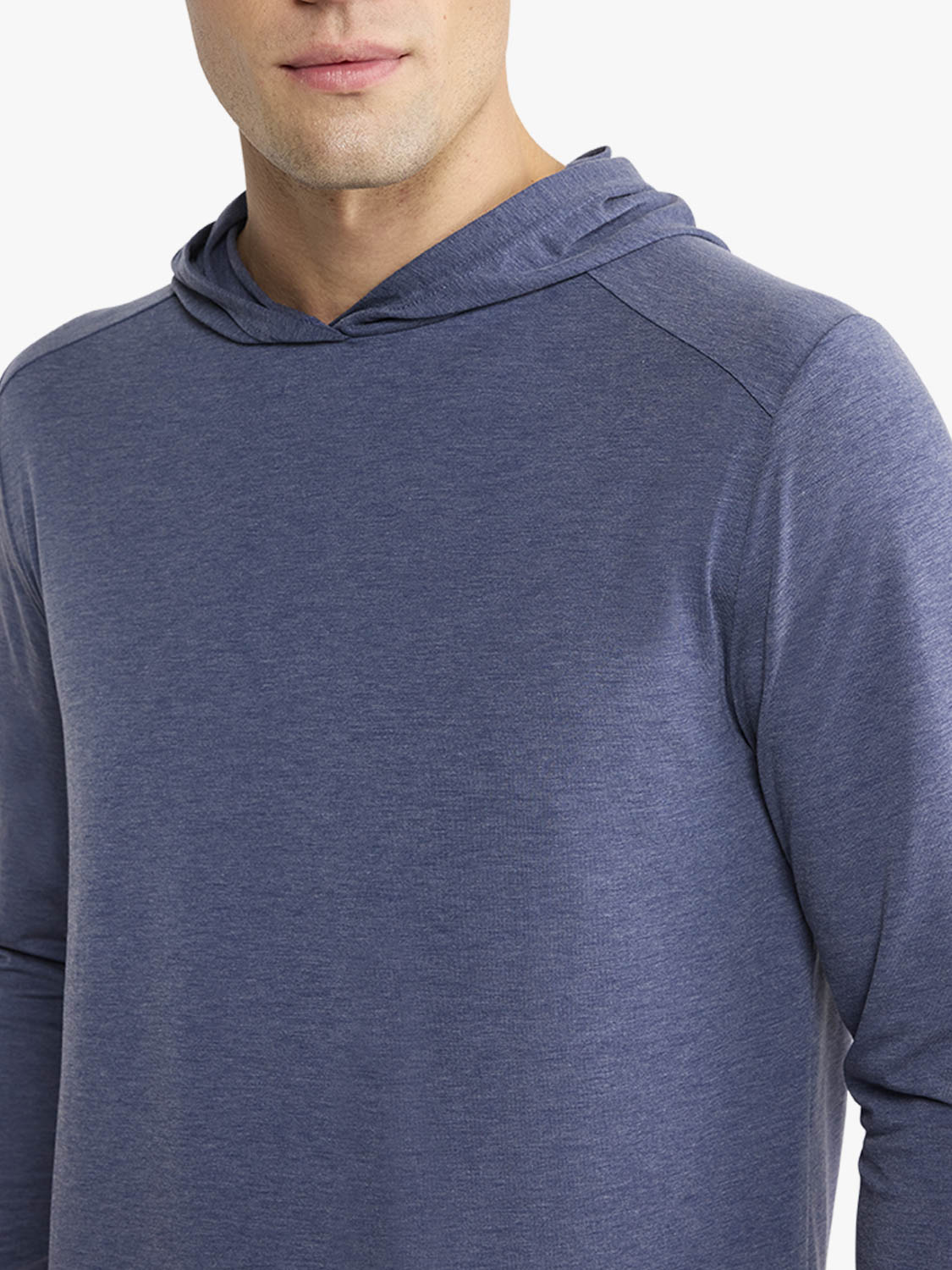 Man wearing a navy blue heathered hoodie with long sleeves and a drawstring hood.