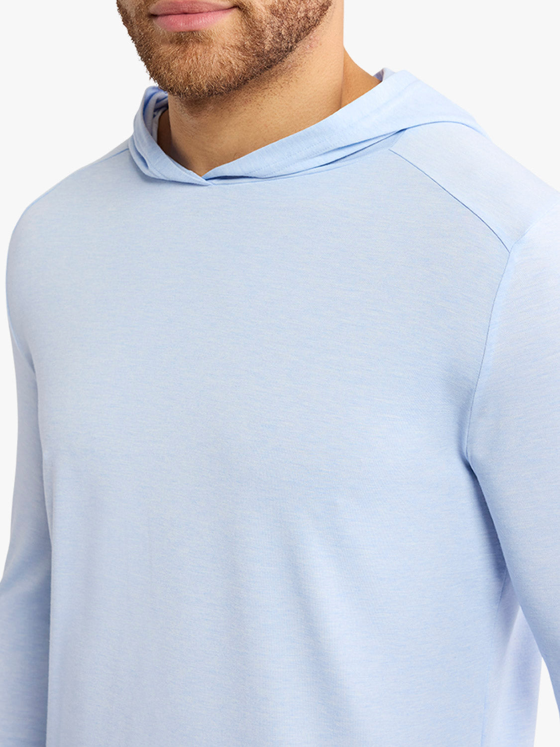 Man wearing a light blue hoodie with a drawstring hood and long sleeves.