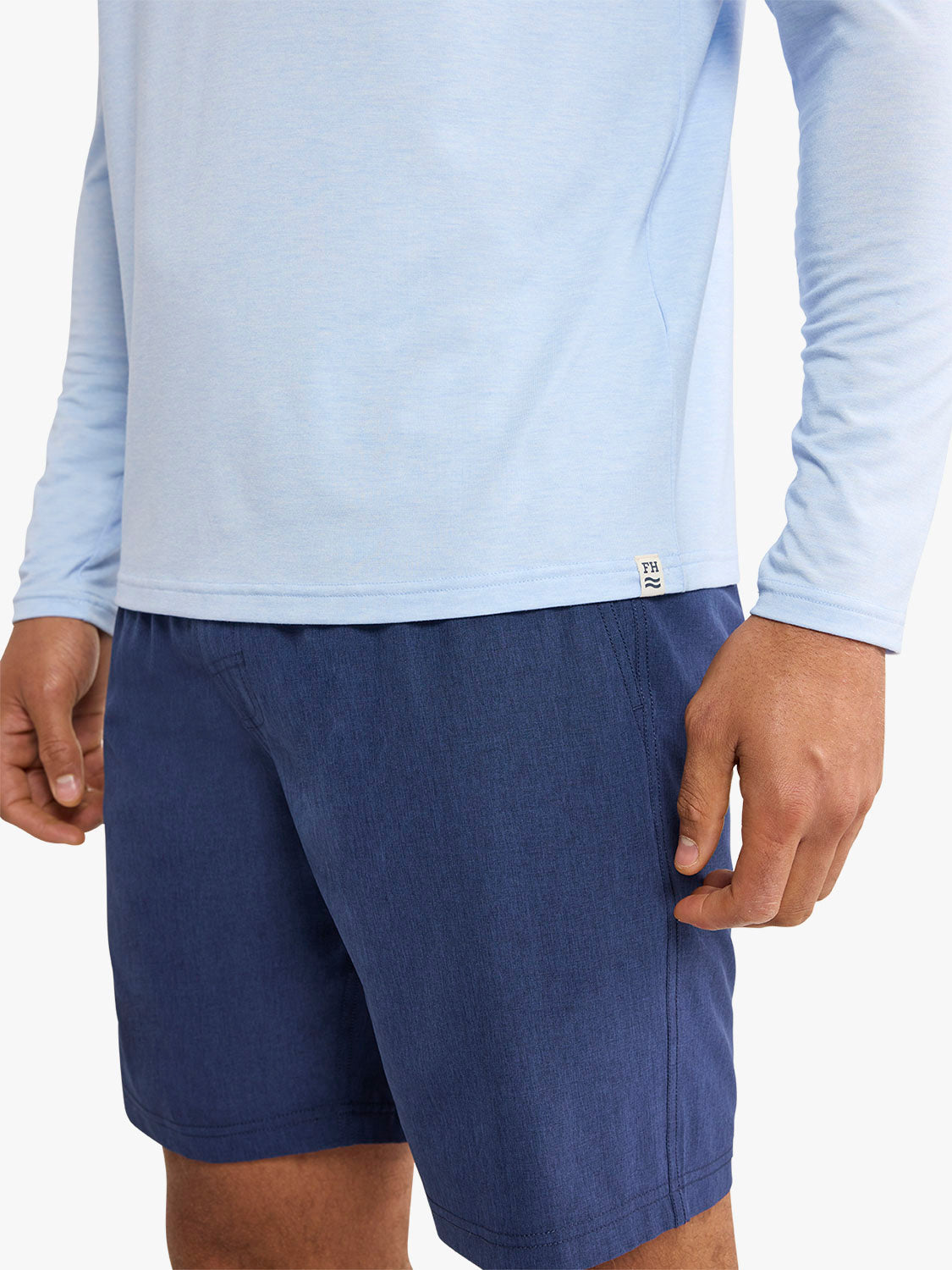 Light blue long-sleeved hoodie worn with dark blue shorts, showing torso and arm details.