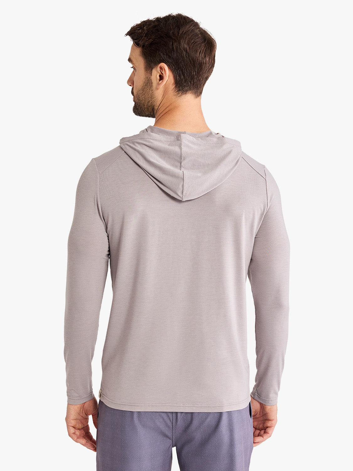 Man wearing a light gray hoodie with long sleeves shown from behind against a white background.