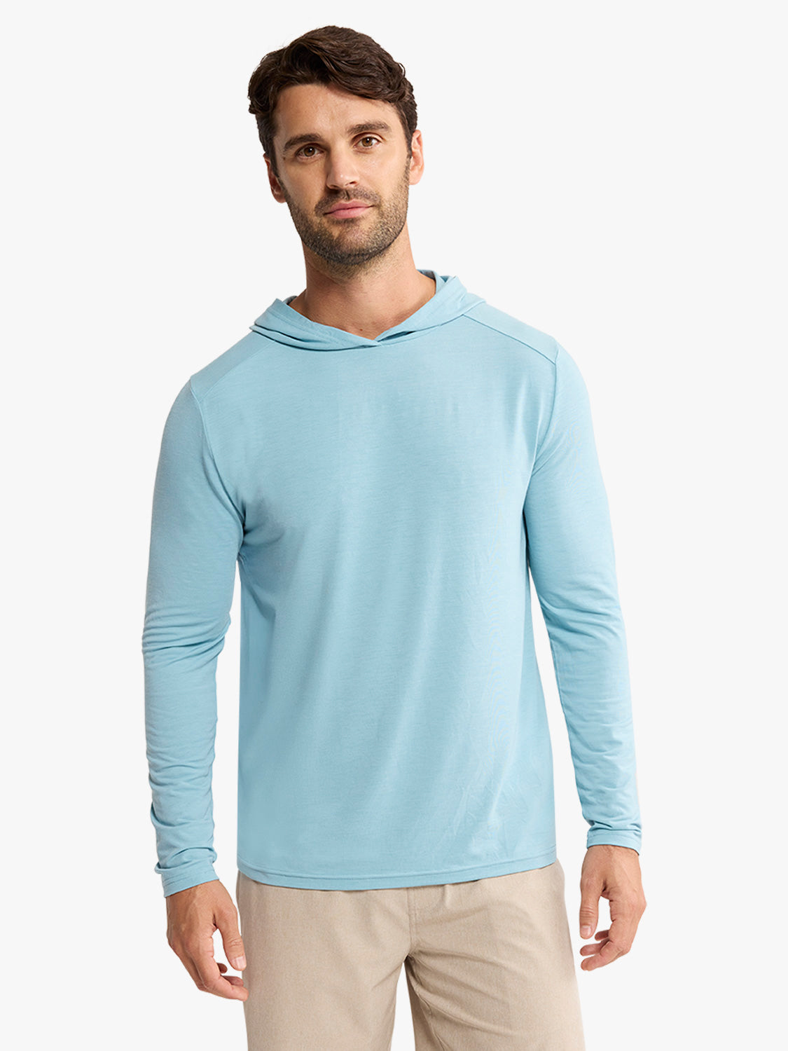 Man wearing a light blue hoodie with long sleeves and a drawstring hood over khaki pants.