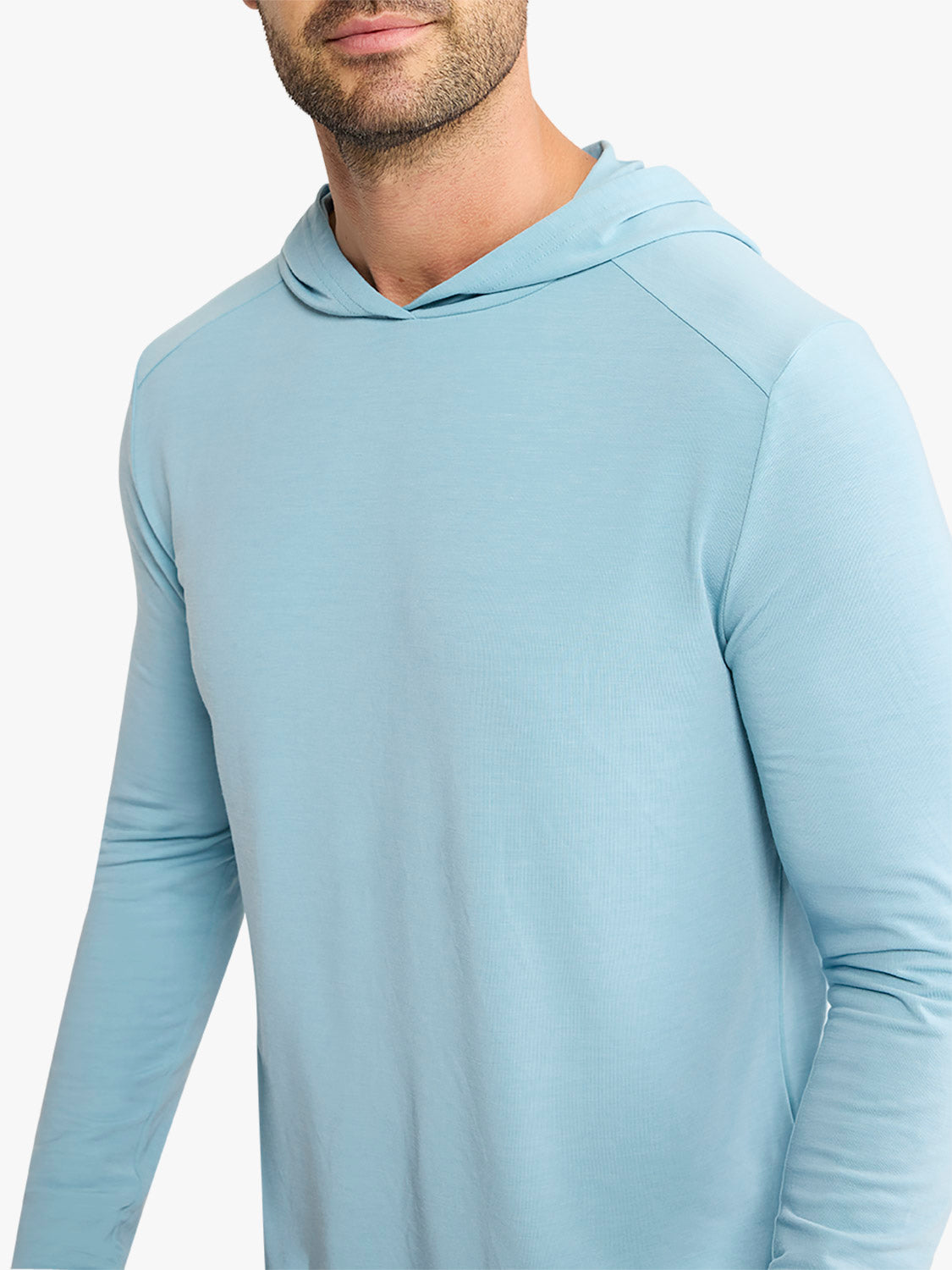 Man wearing a light blue long-sleeve hoodie with a drawstring hood and ribbed texture.
