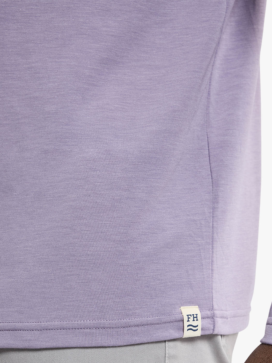 Dusk-colored hoodie with textured fabric and a brand label visible at the hem.