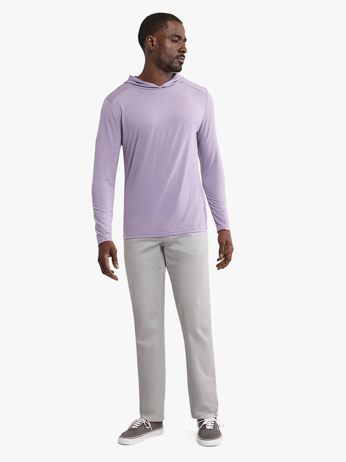 Man wearing a purple dusk-colored hoodie with long sleeves and gray pants.
