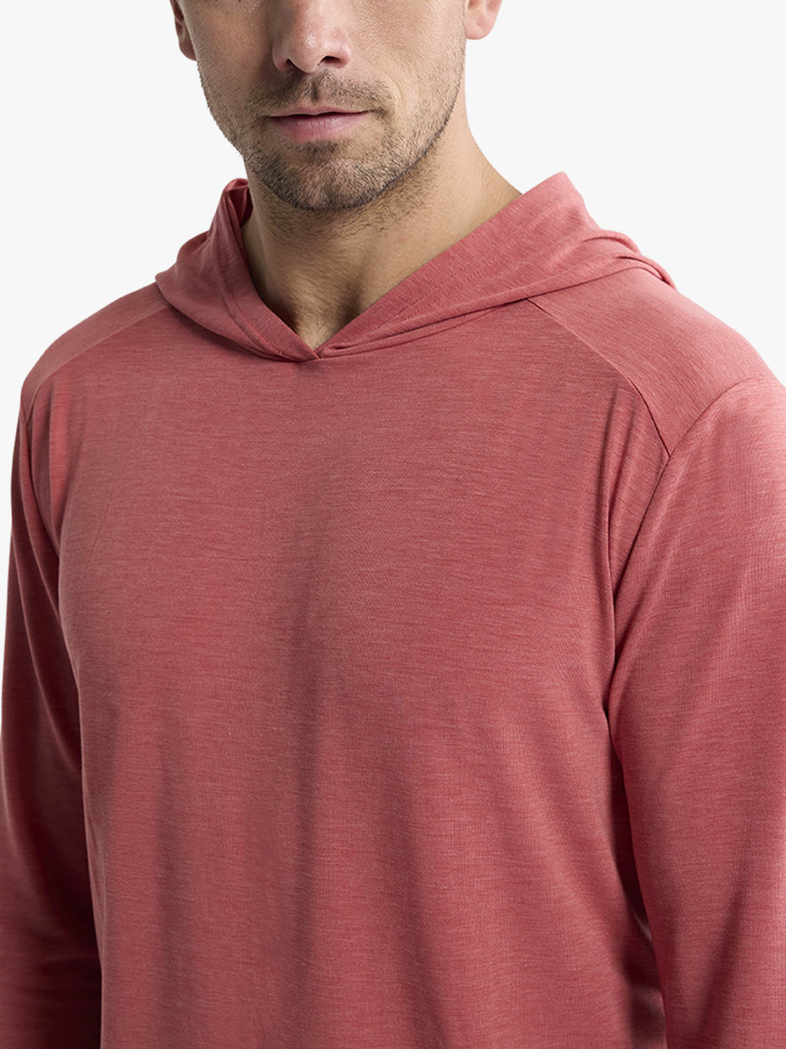Man wearing a mineral red pullover hoodie with a textured knit fabric and ribbed detailing.