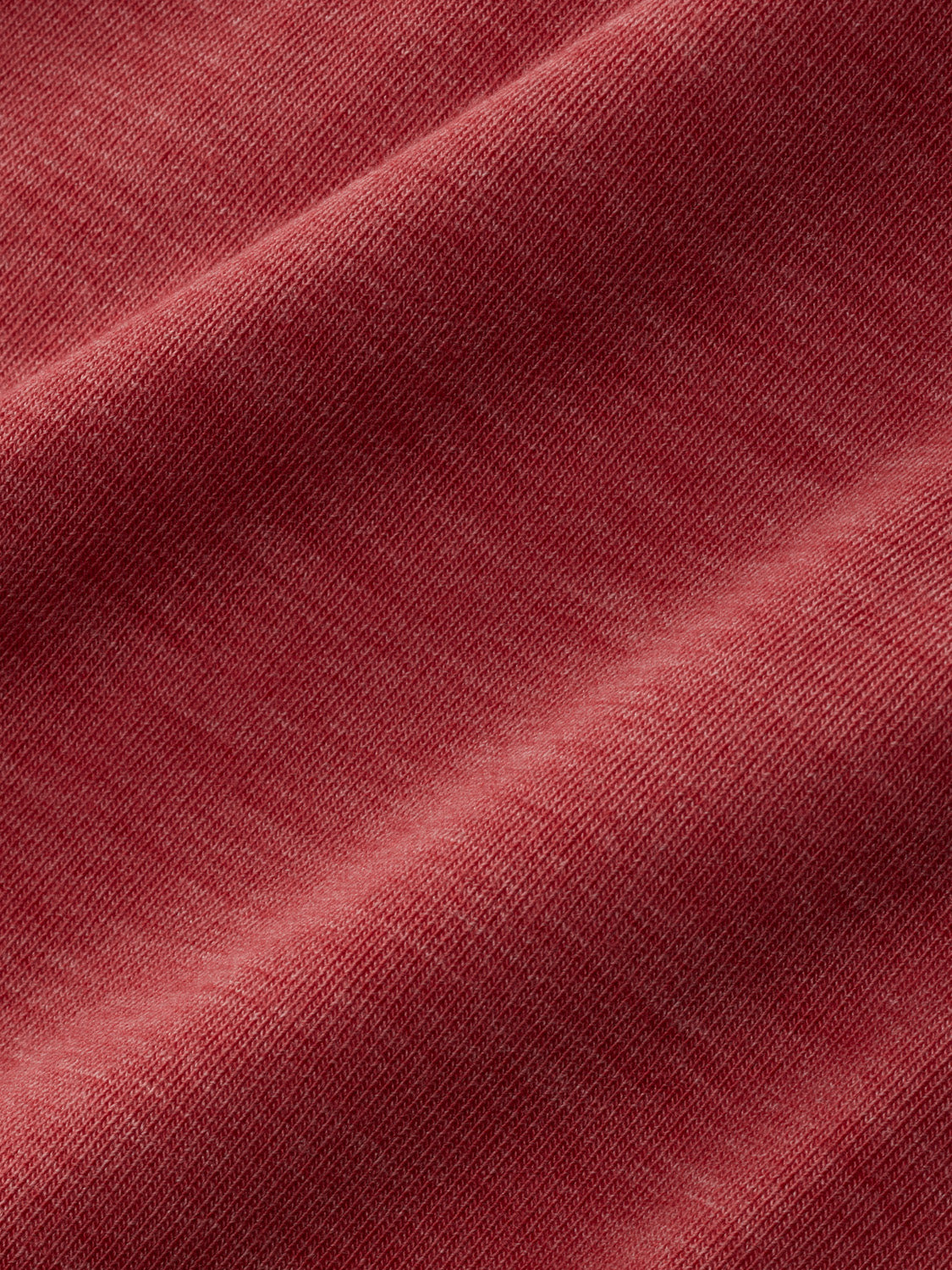 Mineral red hoodie fabric with a textured knit weave and diagonal fold detail.