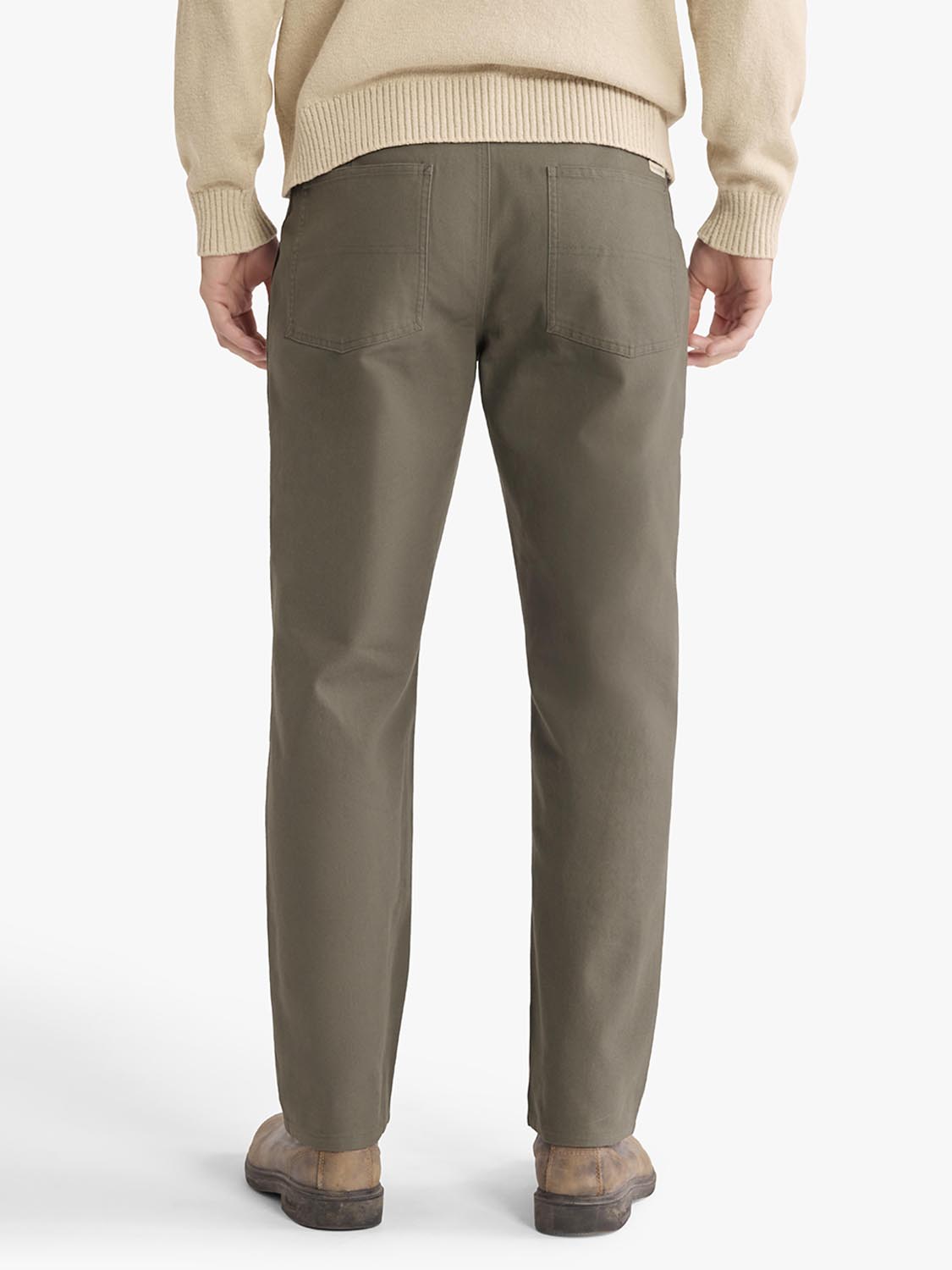 Man wearing olive-colored pants with a cream-colored knit sweater, shown from behind.