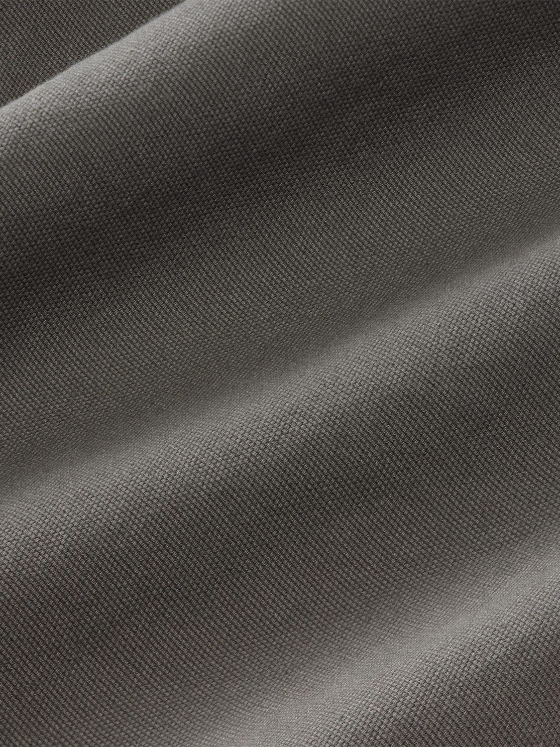 Close-up of olive-colored fabric with a textured weave pattern and subtle folds.