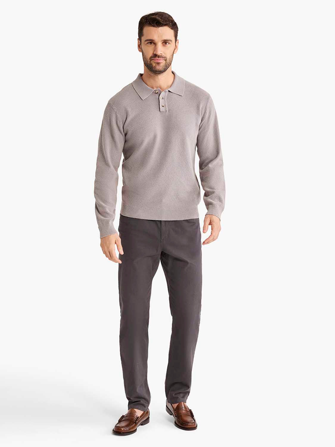 Man wearing a light gray long sleeve polo shirt with a collared neckline and dark gray pants.