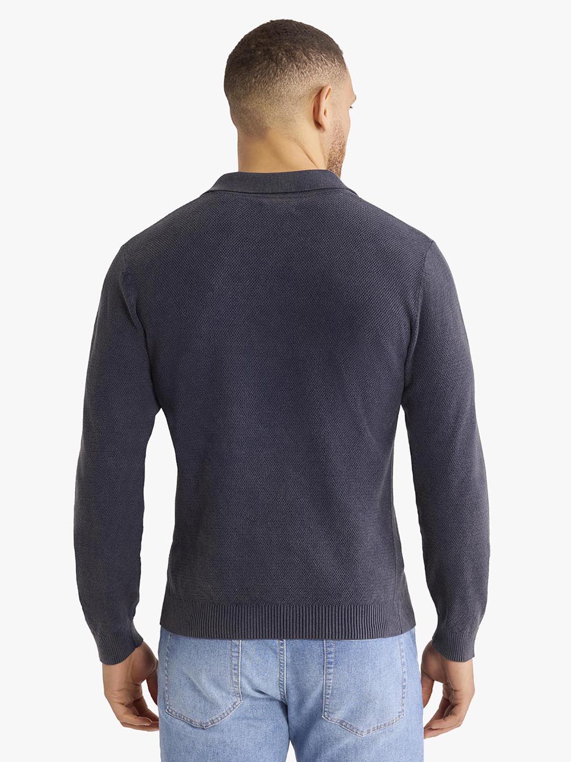 Man wearing navy long sleeve polo shirt with ribbed collar, viewed from the back.