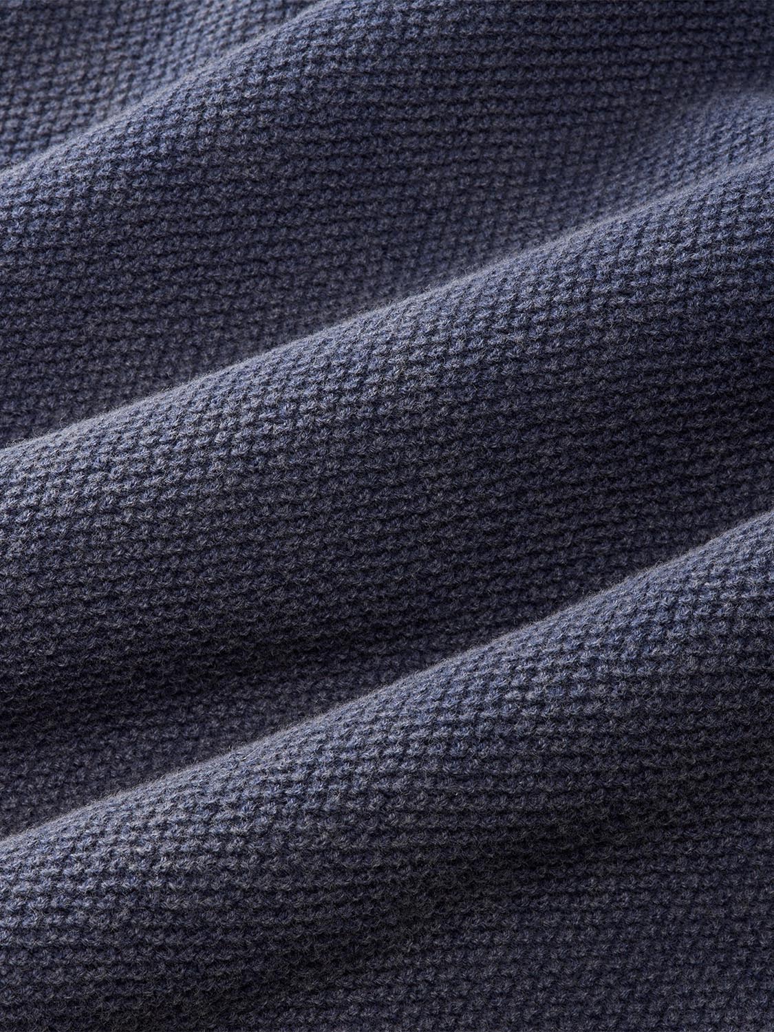 Navy long sleeve polo shirt fabric with textured knit weave and diagonal folds.