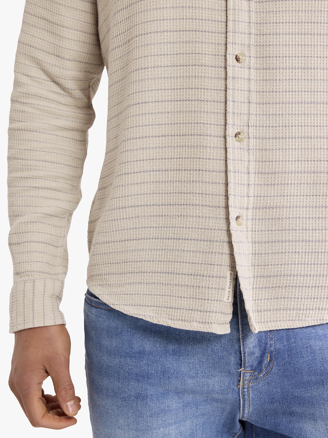 Beige waffle stripe long sleeve button-up shirt worn with blue jeans, showing front placket and textured fabric detail.