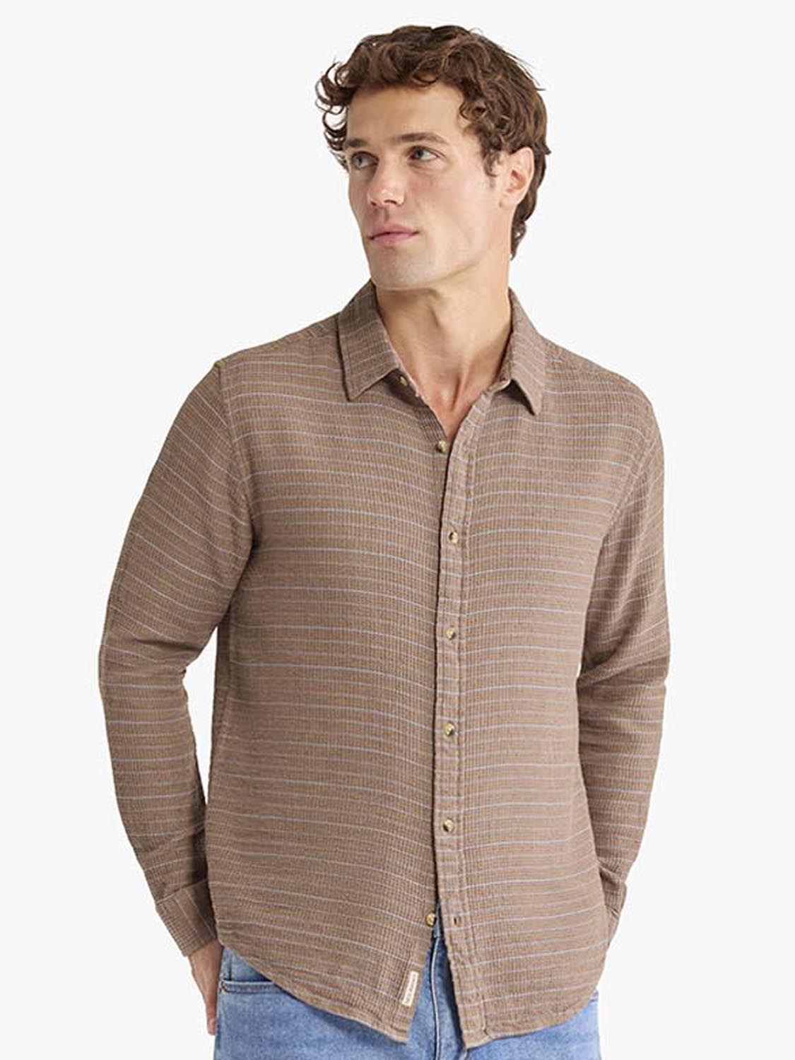 Man wearing a beige and red striped long sleeve button up shirt with a collared neckline.