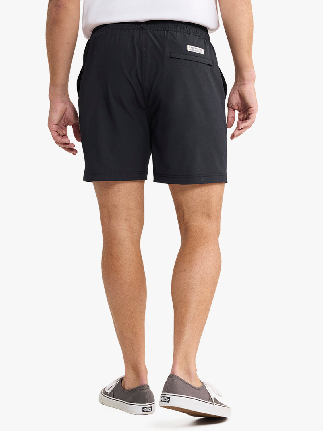 Man wearing black shorts with an elastic waistband and back pocket, paired with a white tank top.