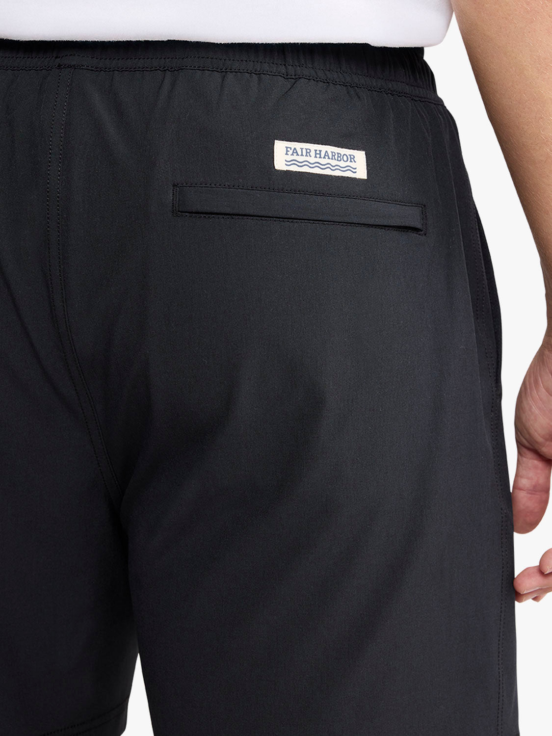 Black shorts with Fair Harbor brand label and back pocket detail visible.