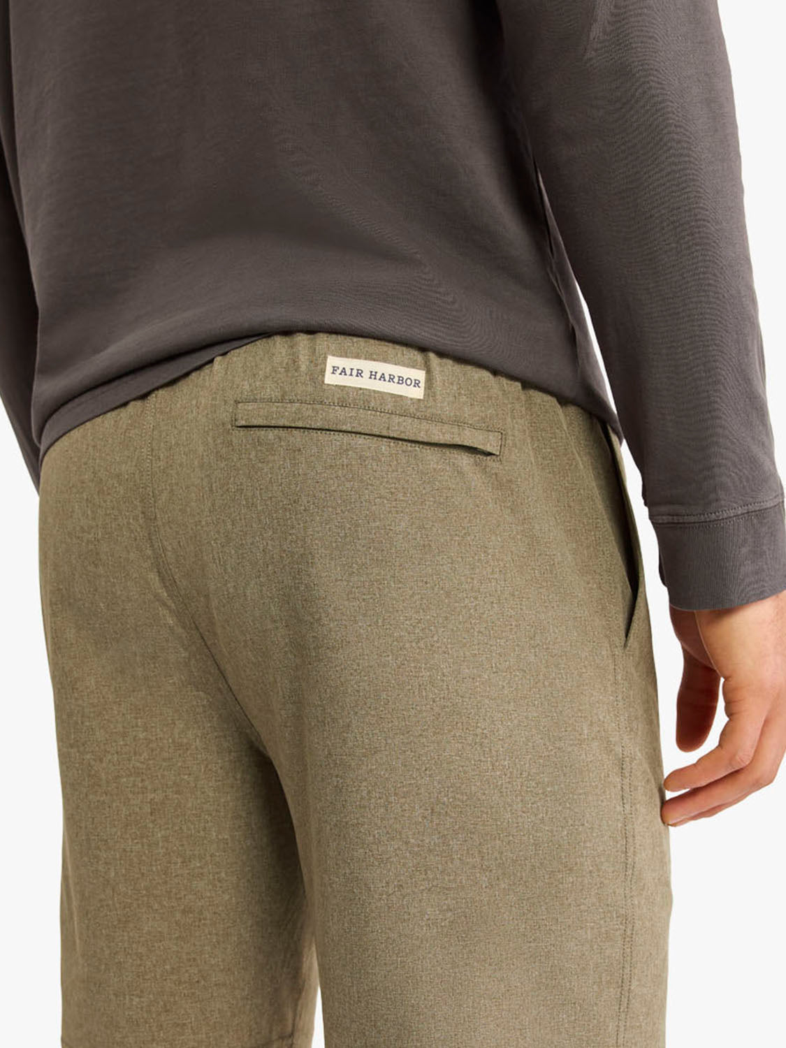 Olive shorts with flat front waistband worn with charcoal long-sleeve shirt, showing back detail.