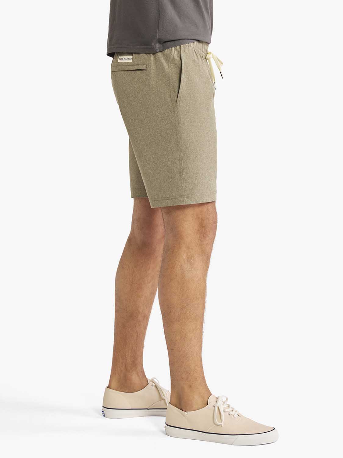 Man wearing olive-colored shorts with drawstring waist and a dark gray shirt above.