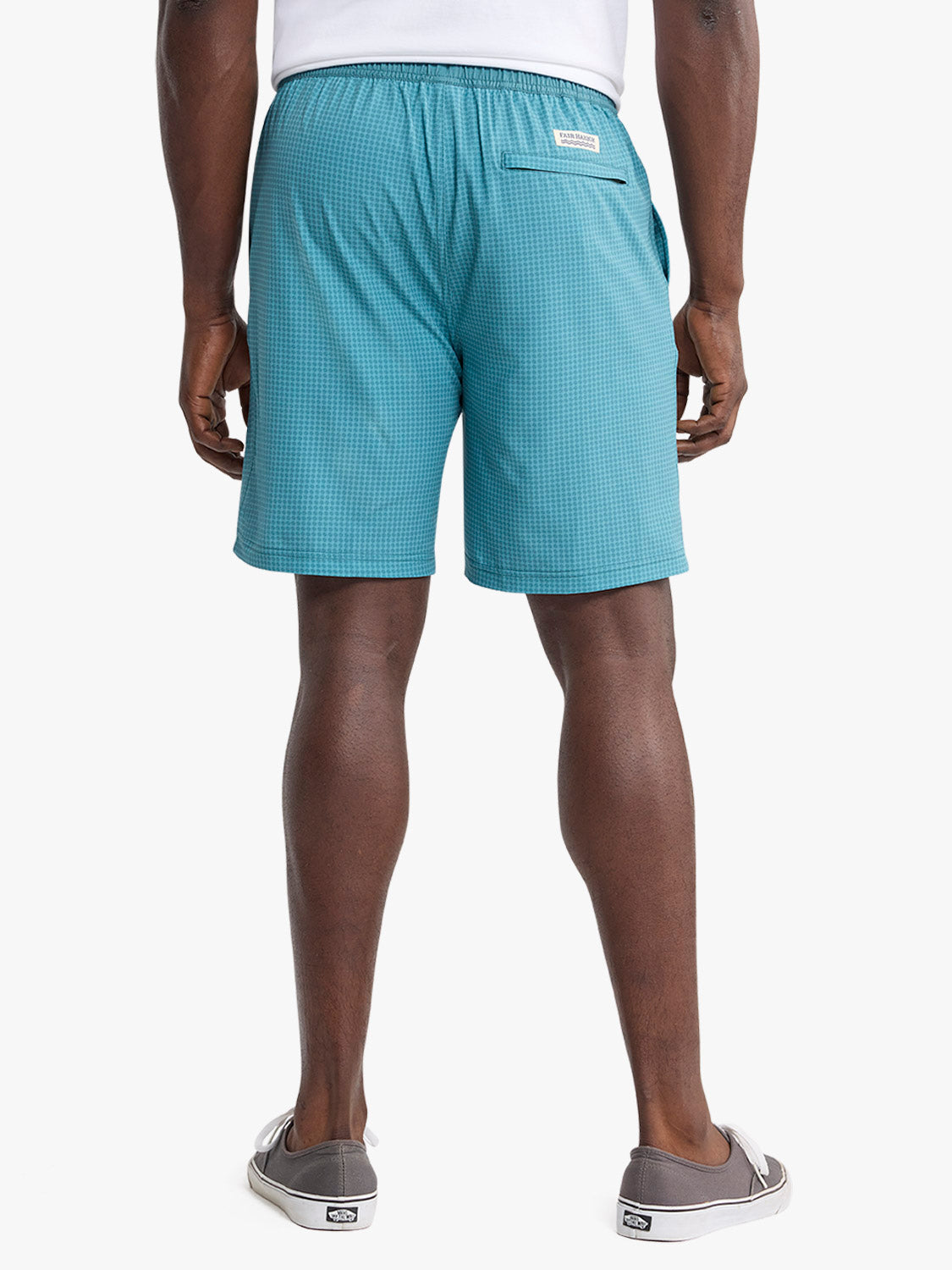 Man wearing teal geometric patterned shorts with back pocket viewed from behind.