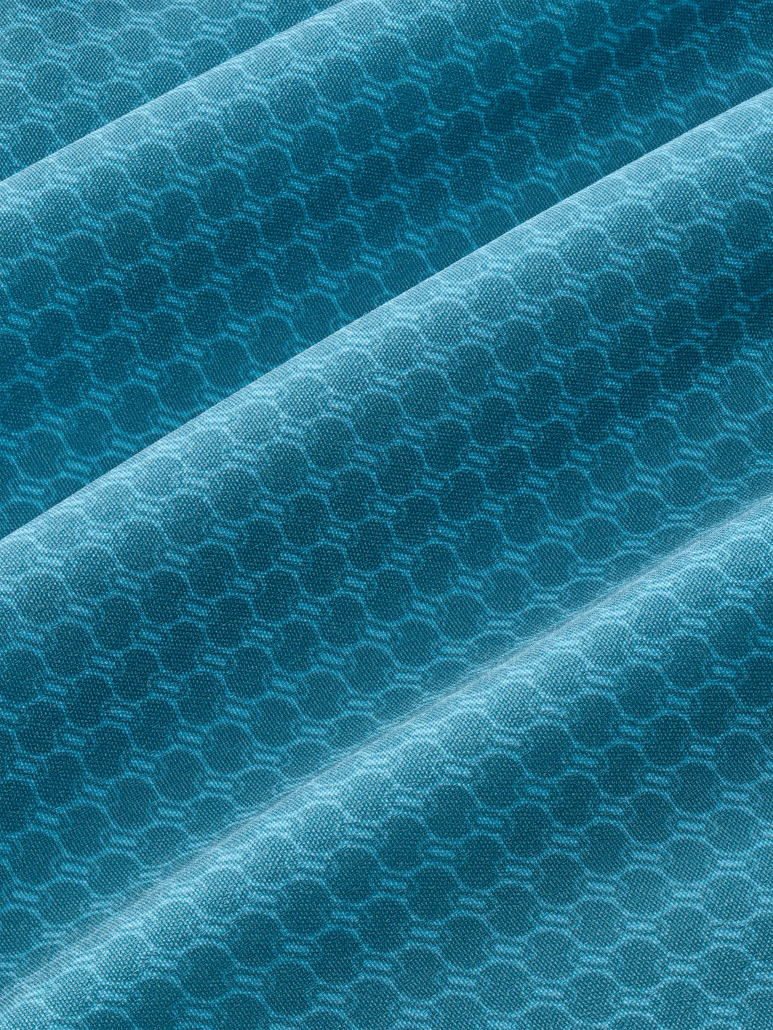 Teal fabric with geometric wave pattern and diagonal folds throughout the textile surface.