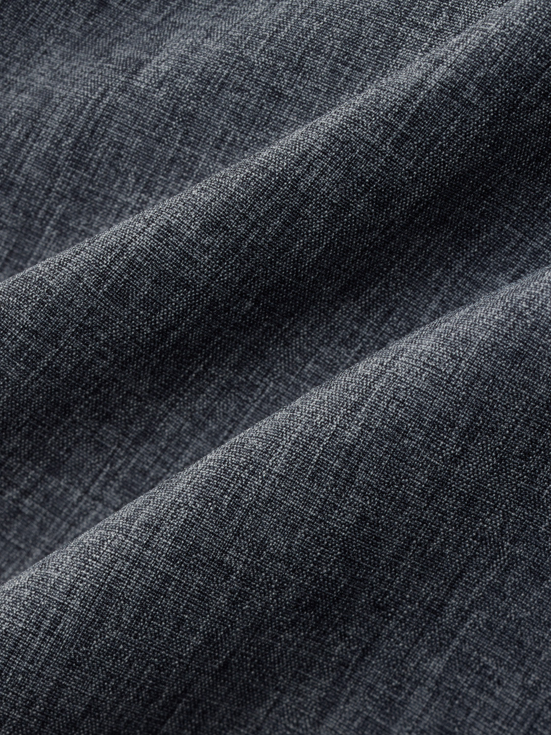 Grey woven fabric with diagonal folds and a textured, matte surface finish.