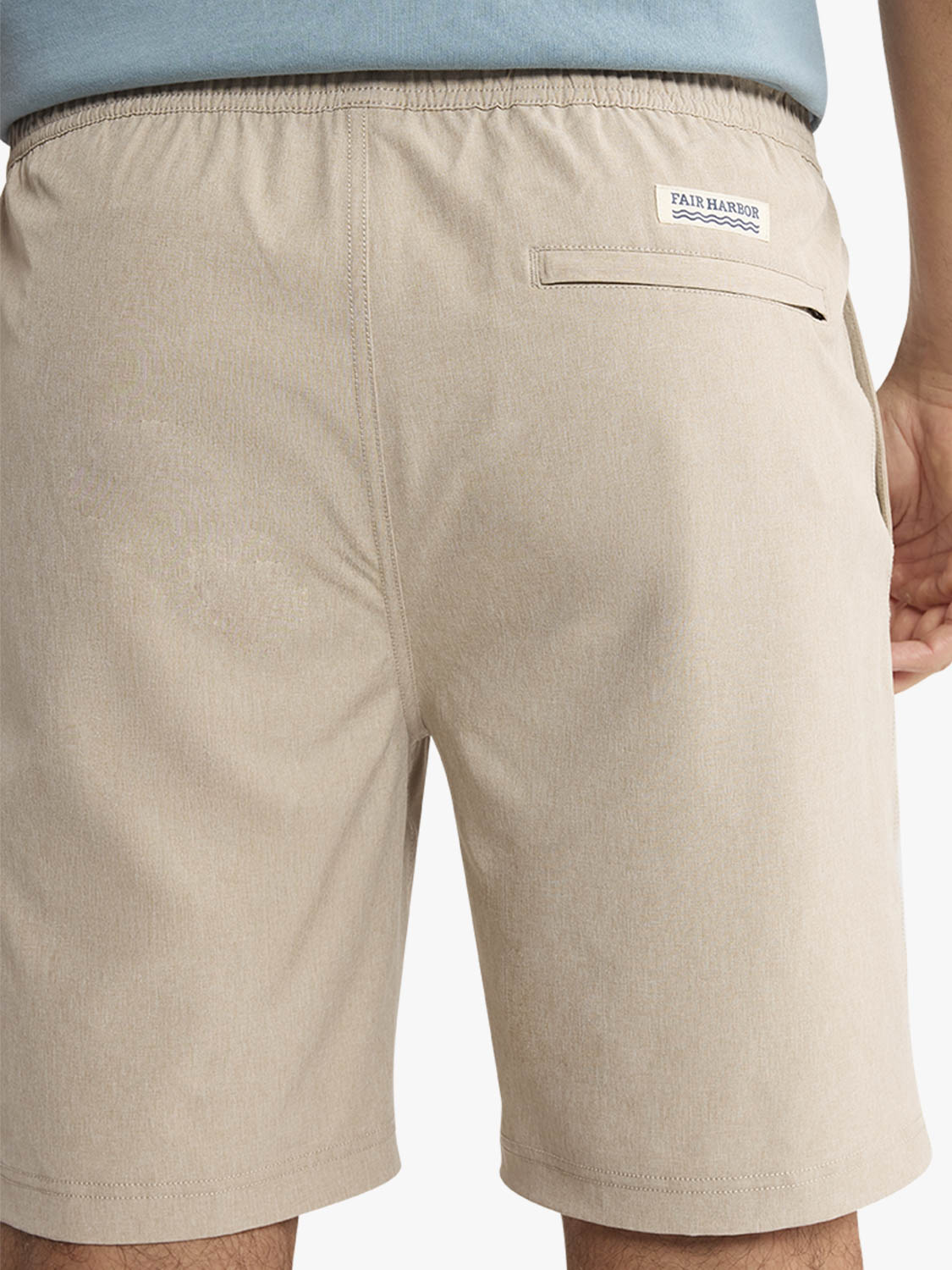Khaki shorts with an elastic waistband and back pocket, worn with a blue shirt.