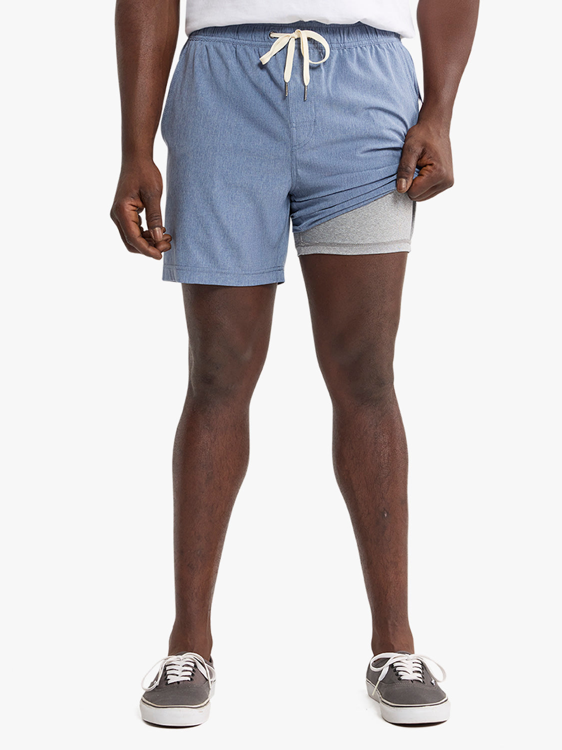 Man wearing blue shorts with cream drawstring and grey undershorts visible underneath.