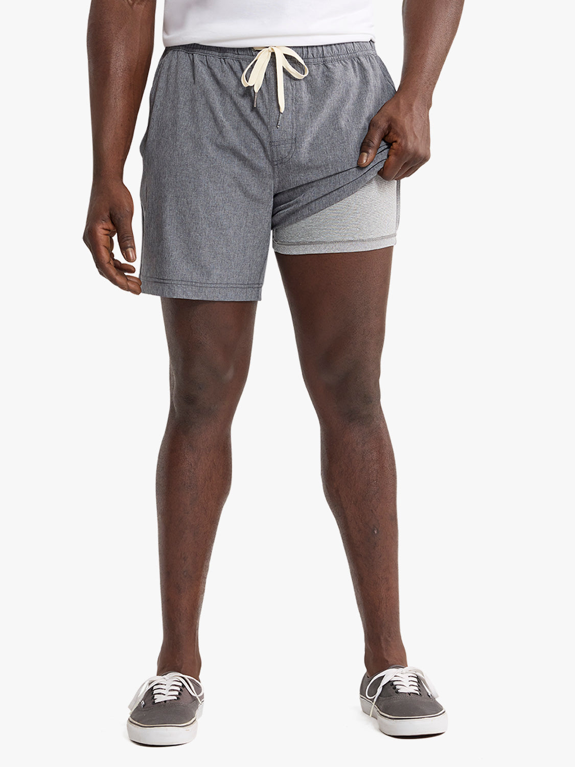 Man wearing grey shorts with cream drawstring and white and grey undershorts visible.