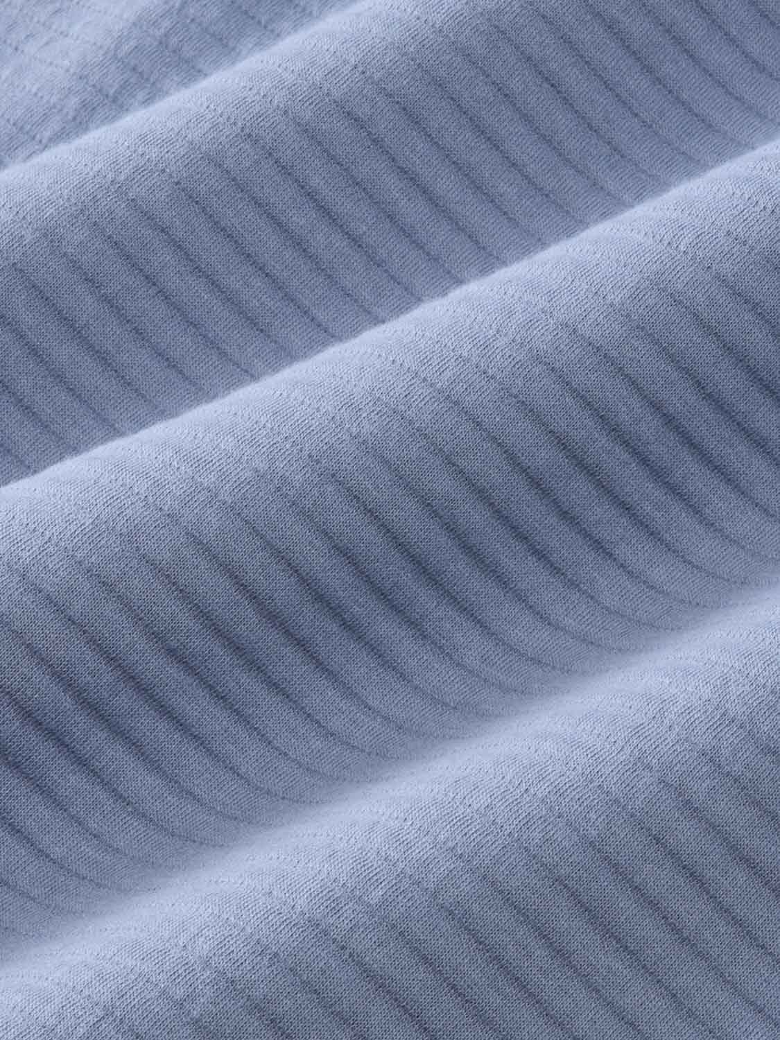 Blue maritime quarter zip garment fabric showing ribbed knit texture and diagonal folds.