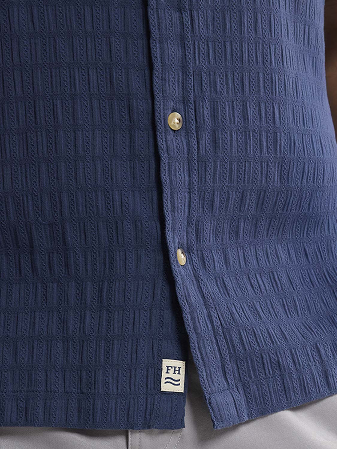 Navy textured shirt with basket weave pattern and mother-of-pearl buttons visible on front.