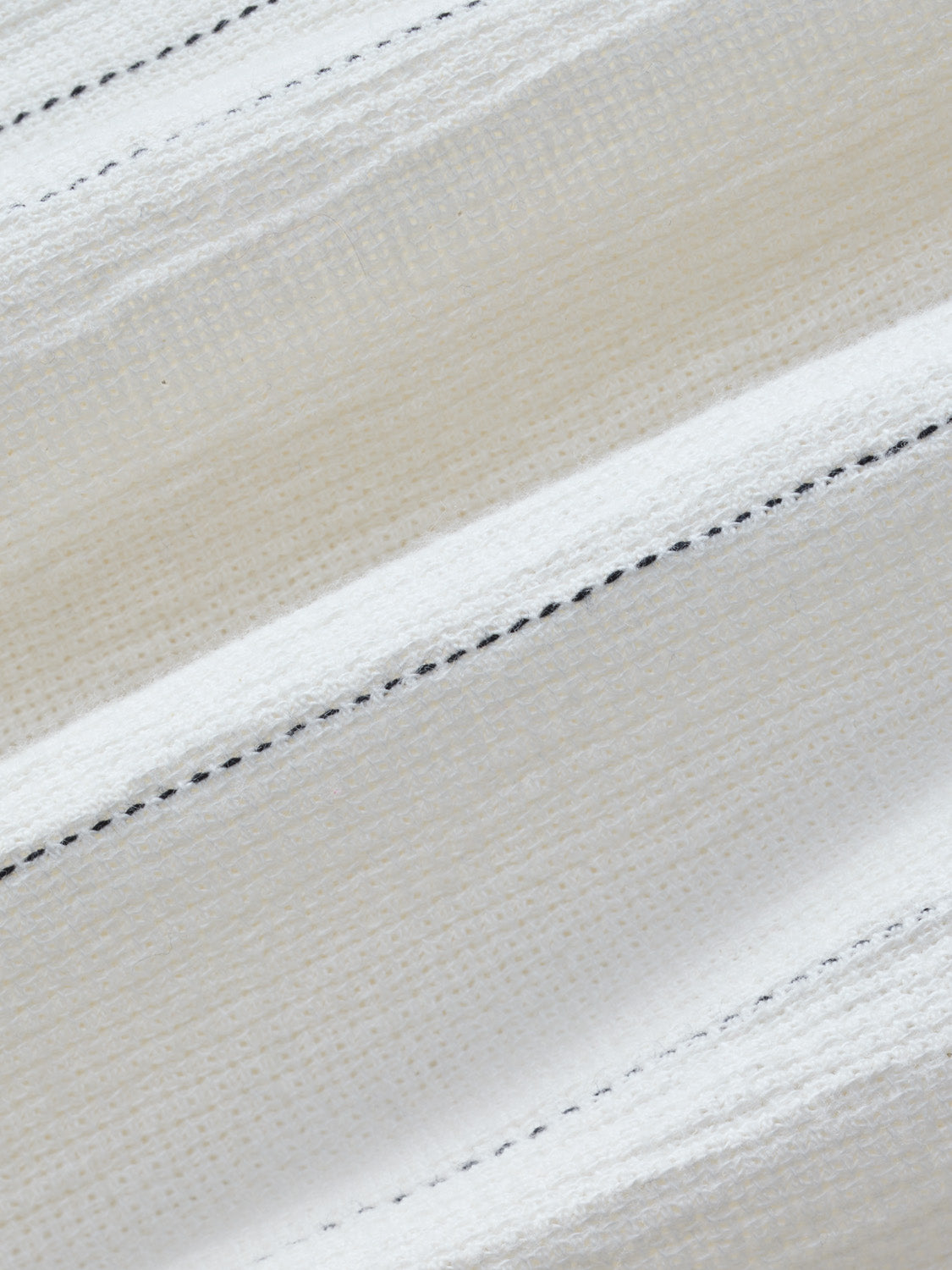 Cream and white textured fabric with horizontal stripes separated by black dashed stitching.