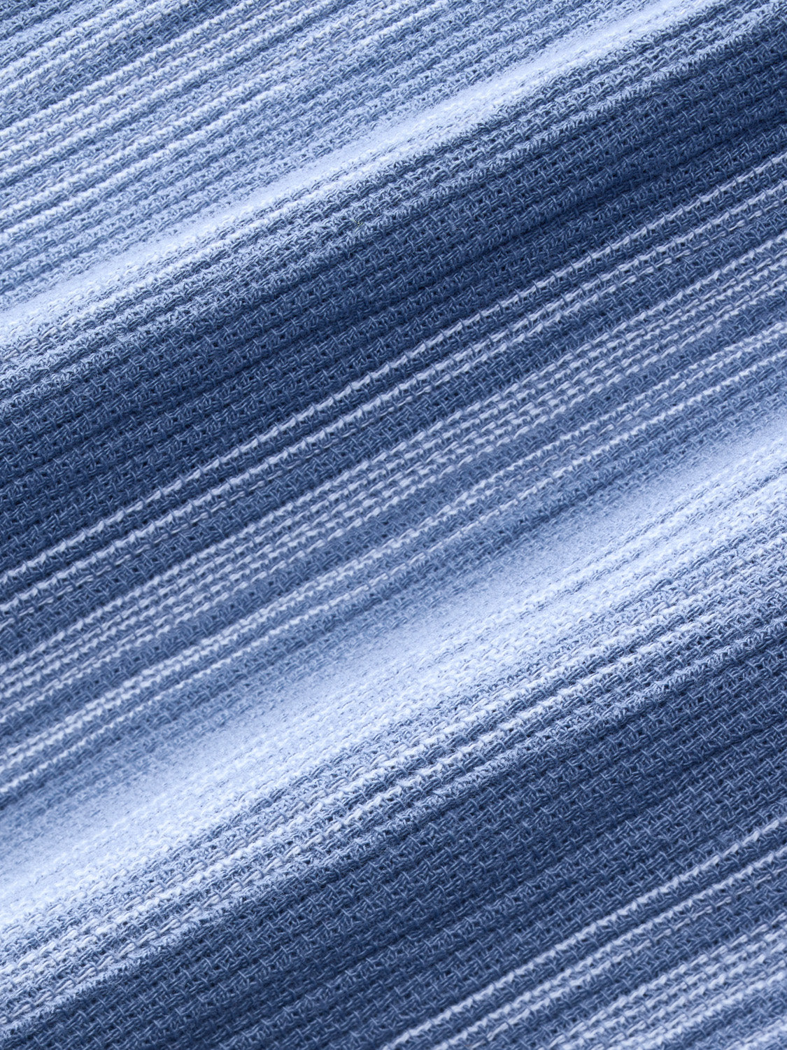 Blue and white striped textured shirt fabric with diagonal diagonal ribs and woven maritime pattern detail.