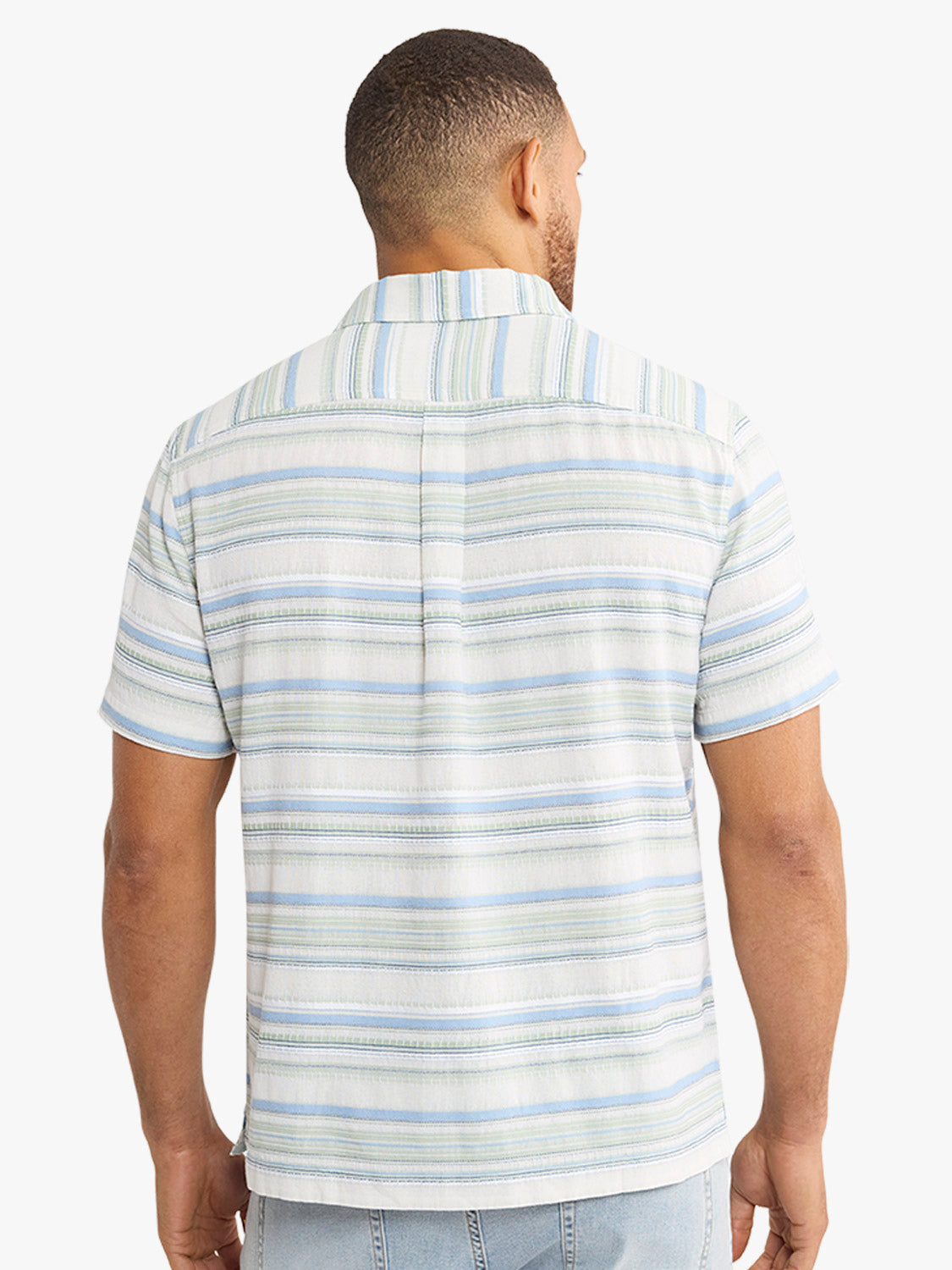 Man wearing short-sleeved textured shirt with horizontal blue and green stripes on white background.