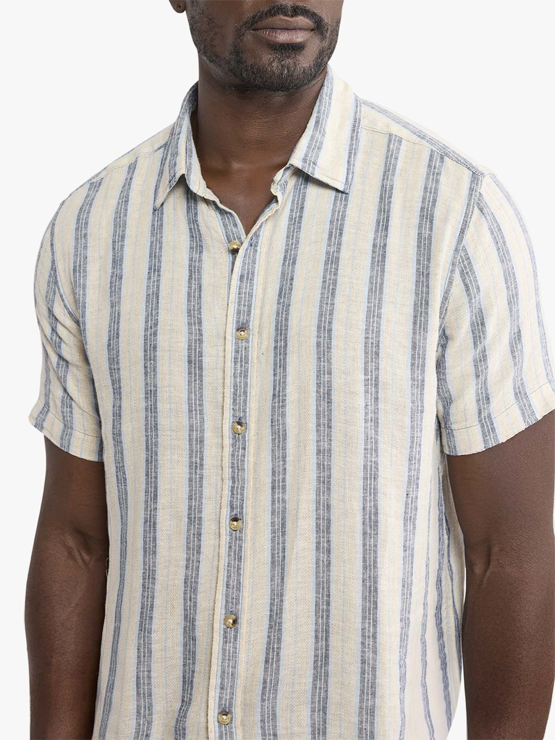 Man wearing a short-sleeve button-up shirt with vertical blue and cream stripes and textured fabric.