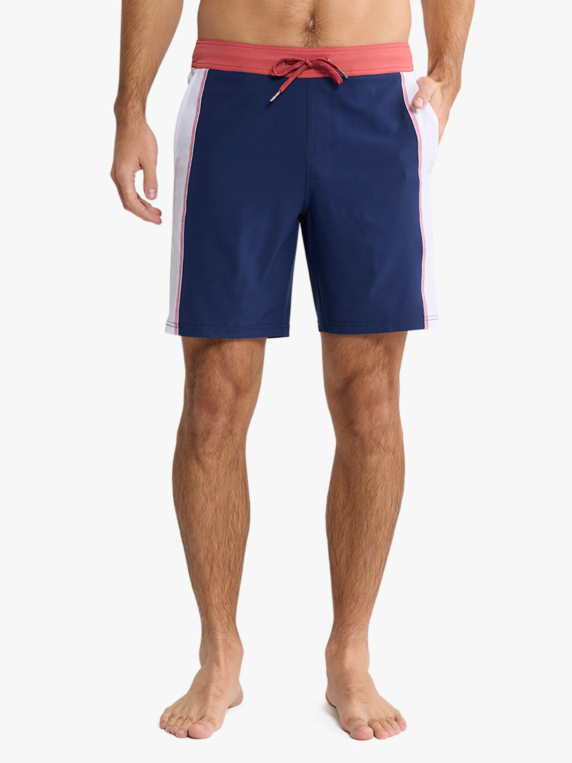 Man wearing navy blue board shorts with red waistband, white side stripes, and red drawstring tie.