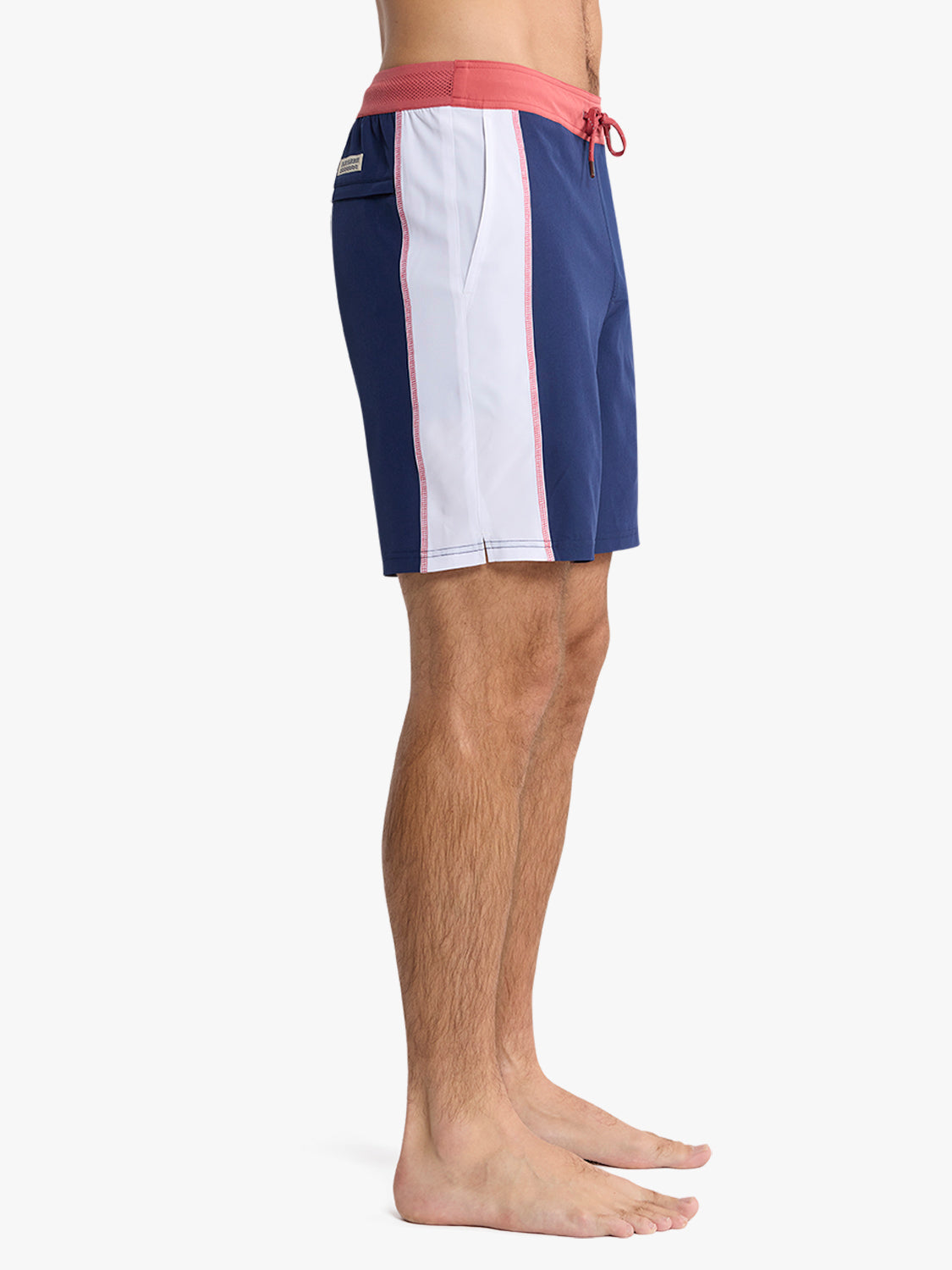 Navy and white board shorts with red sail trim and drawstring waistband on male model.