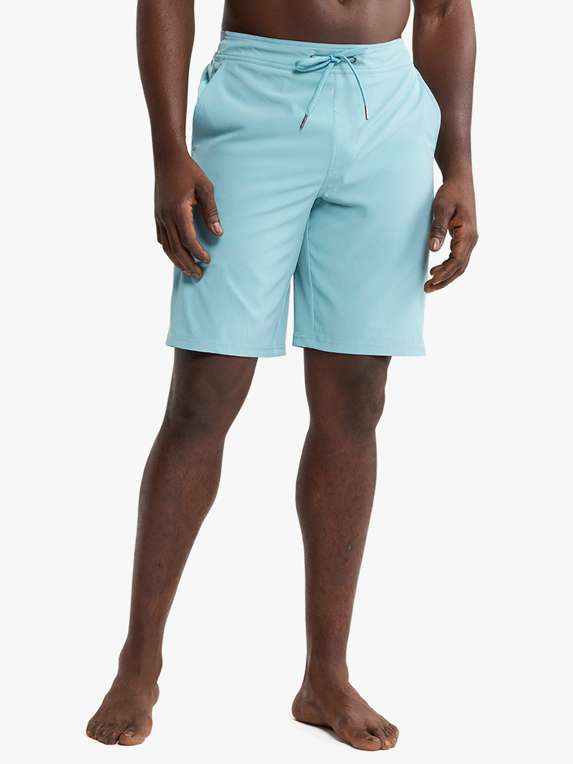 Man wearing light blue drawstring shorts that end above the knee with a solid color design.