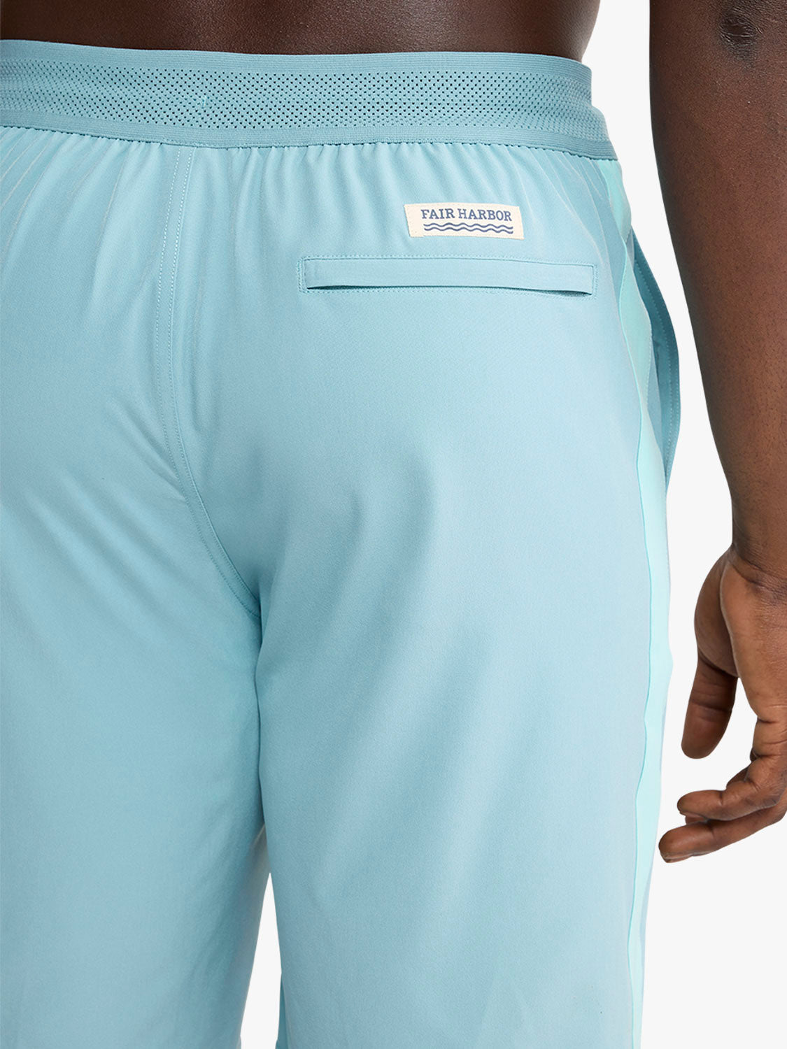 Bay blue swim short with mesh waistband, back pocket, and lighter stripe detail on legs.