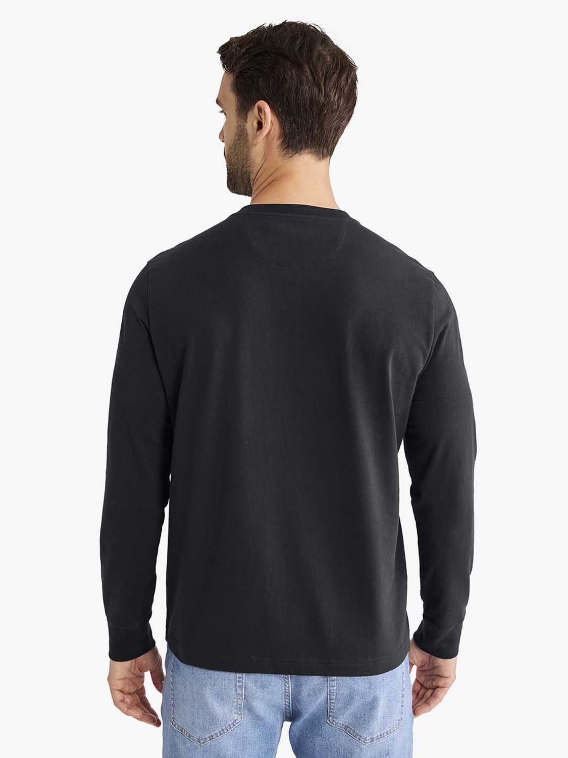 Man wearing black long-sleeve henley shirt and light blue jeans, shown from behind.