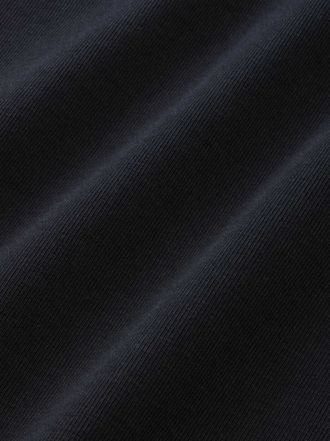 Black ribbed henley shirt displaying textured fabric surface with diagonal light and shadow.