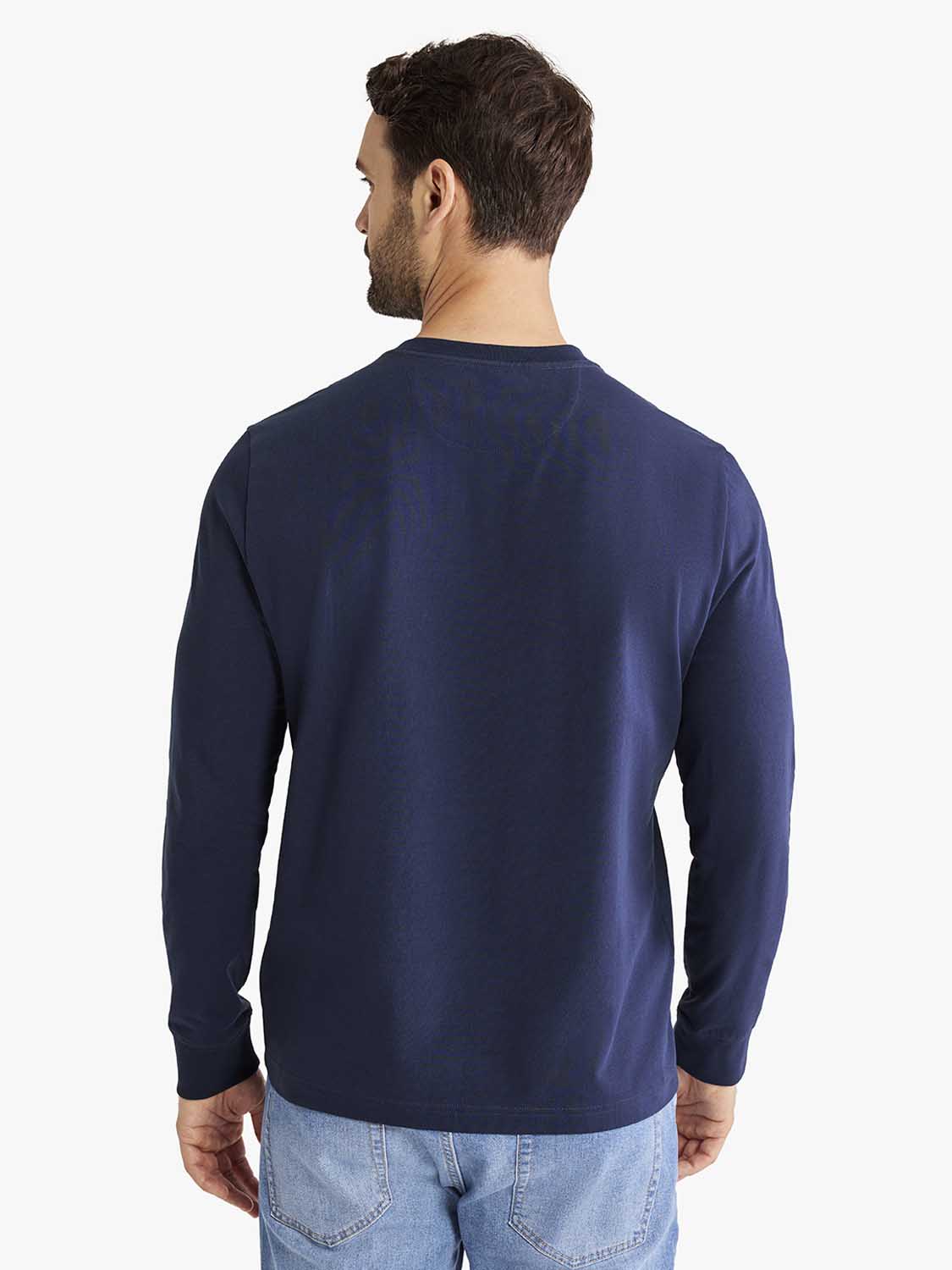 Man wearing navy long-sleeve henley shirt with button placket, shown from back view.
