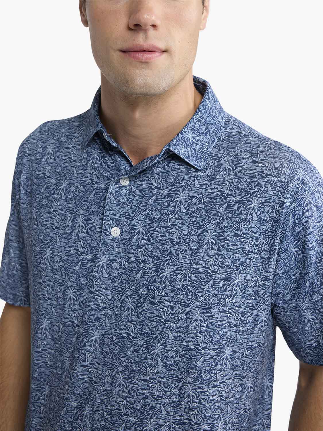Man wearing a blue lisle polo shirt with a tropical palm tree pattern and white buttons.