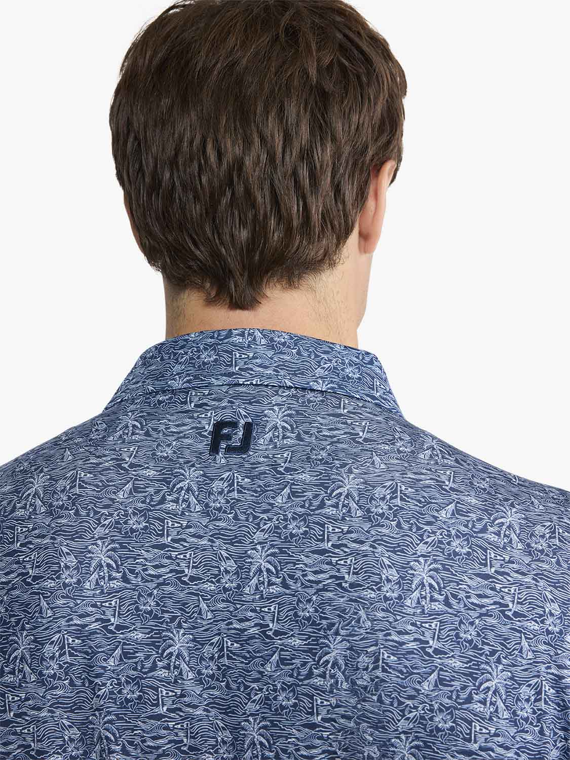 Man wearing blue polo shirt with tropical sailboat and palm tree print viewed from back.