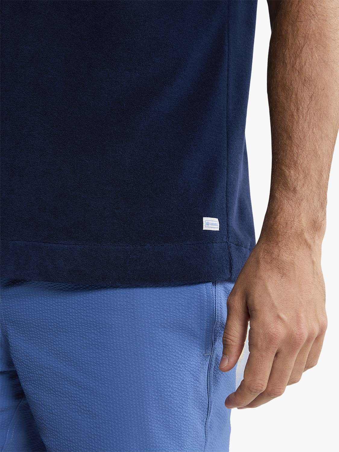 Navy terry short sleeve button up shirt worn with blue shorts on a man.