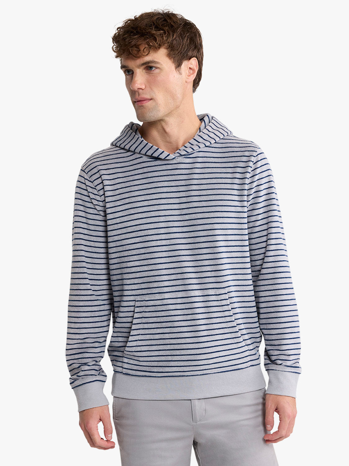 Man wearing a navy and white striped terry hoodie with kangaroo pocket and gray cuffs.